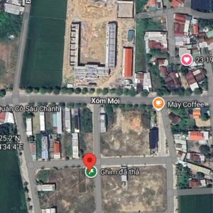 Satellite map view of a construction site with an L-shaped building under construction, surrounded by roads and houses; a red location pin marks 'Ghim đá thả' area in Xóm Mới, Vietnam.