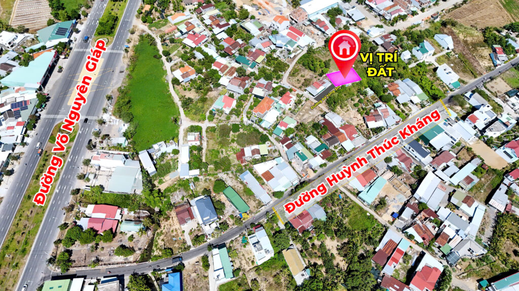 Aerial view of a dense residential area with a large red pin marking a land location labeled 'VỊ TRÍ ĐẤT' beside a pink platform and nearby roads labeled in Vietnamese.